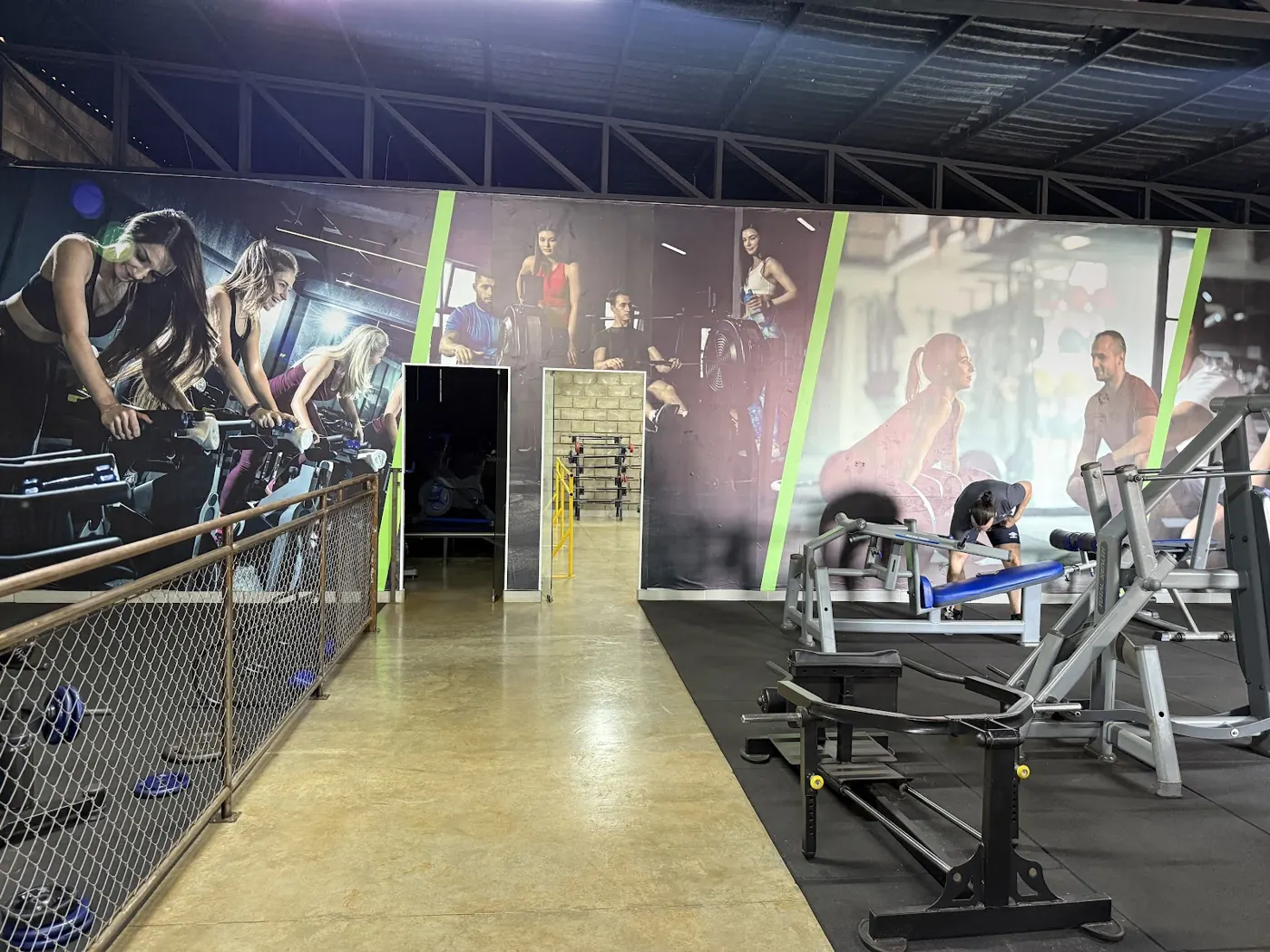 Área de aparelhos com um painel grande de aula de spinning na parede