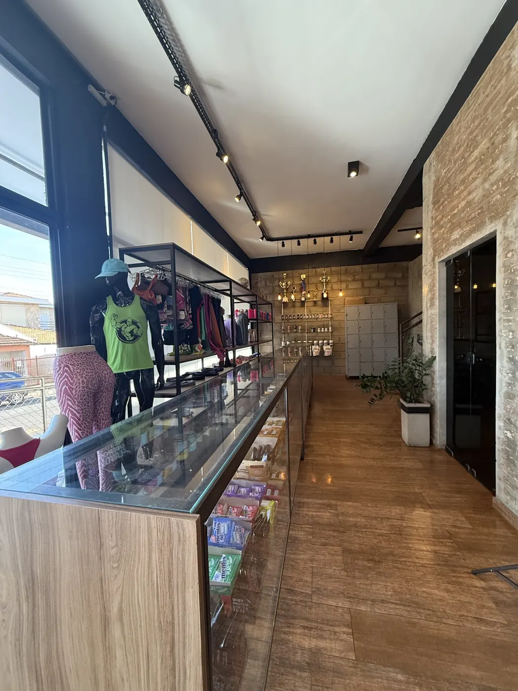 Corredor da entrada com a vitrine da loja de roupas e artigos esportivos